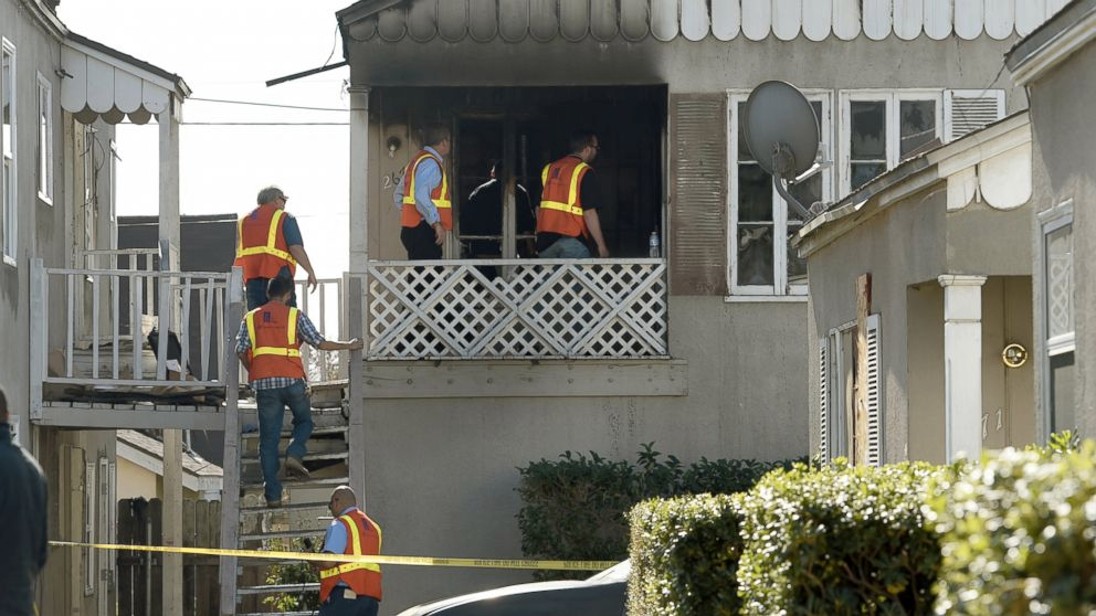 Southern California Gas Company officials enter an apartment that caught fire killing two children ages 2 and 6 in San Bernardino, Calif., Thursday, Nov. 20, 2014. The children were killed early Thursday in the California apartment fire that broke out hours after their mother went to a hospital to give birth, authorities said. The children's father was critically injured in the blaze at the two-story duplex, fire Battalion Chief Michael Bilheimer said. (AP Photo/The Sun, John Valenzuela