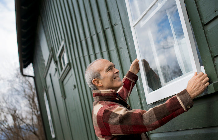 man installing a storm window