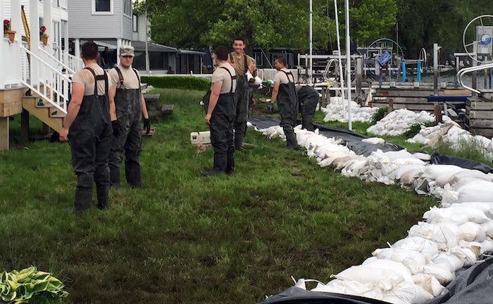 men placing sandbags in floodzone